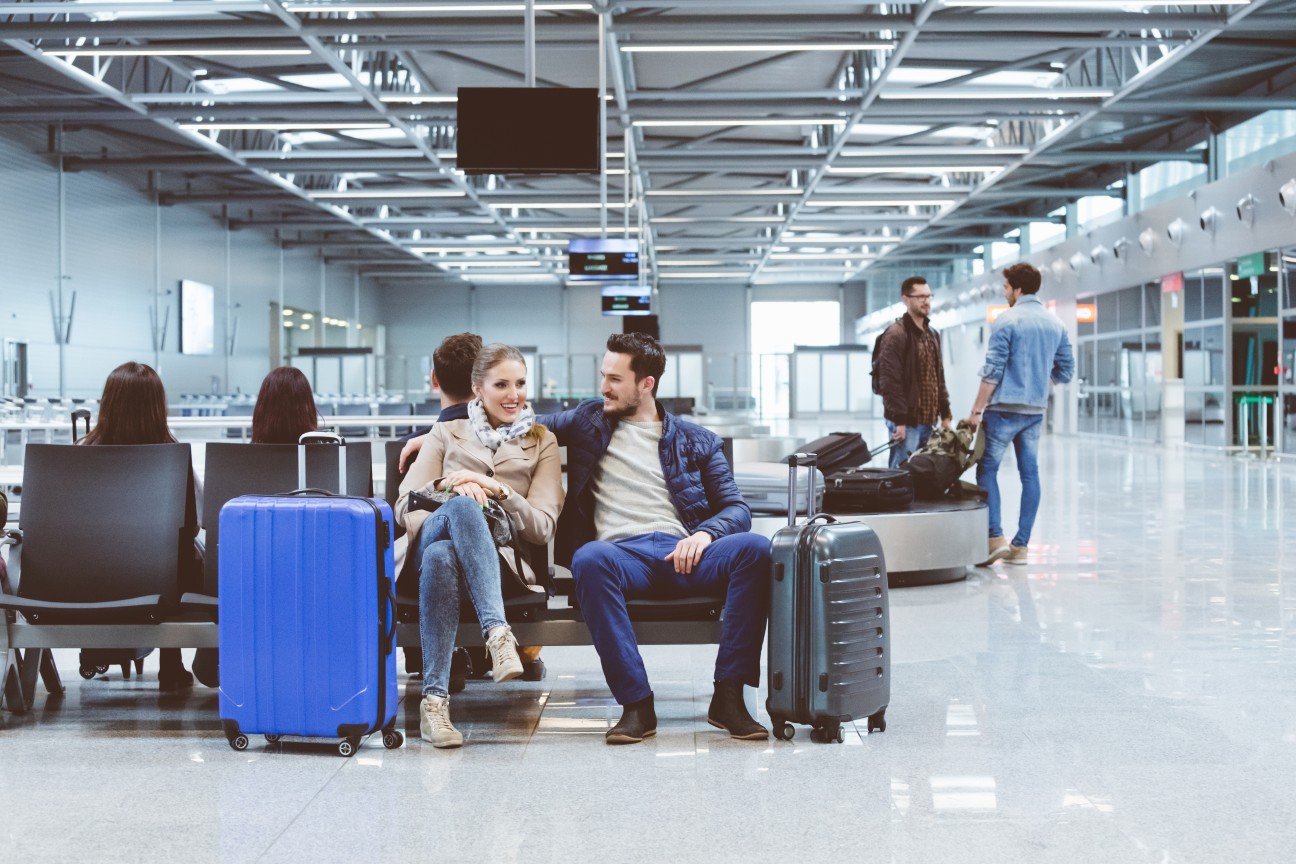 Casal aguardando um voo na sala de embarque de um aeroporto