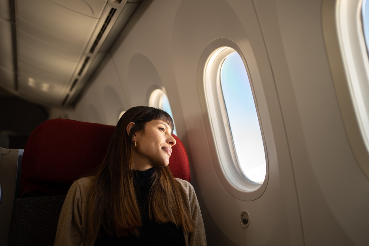 Mulher no avião olhando pela janela